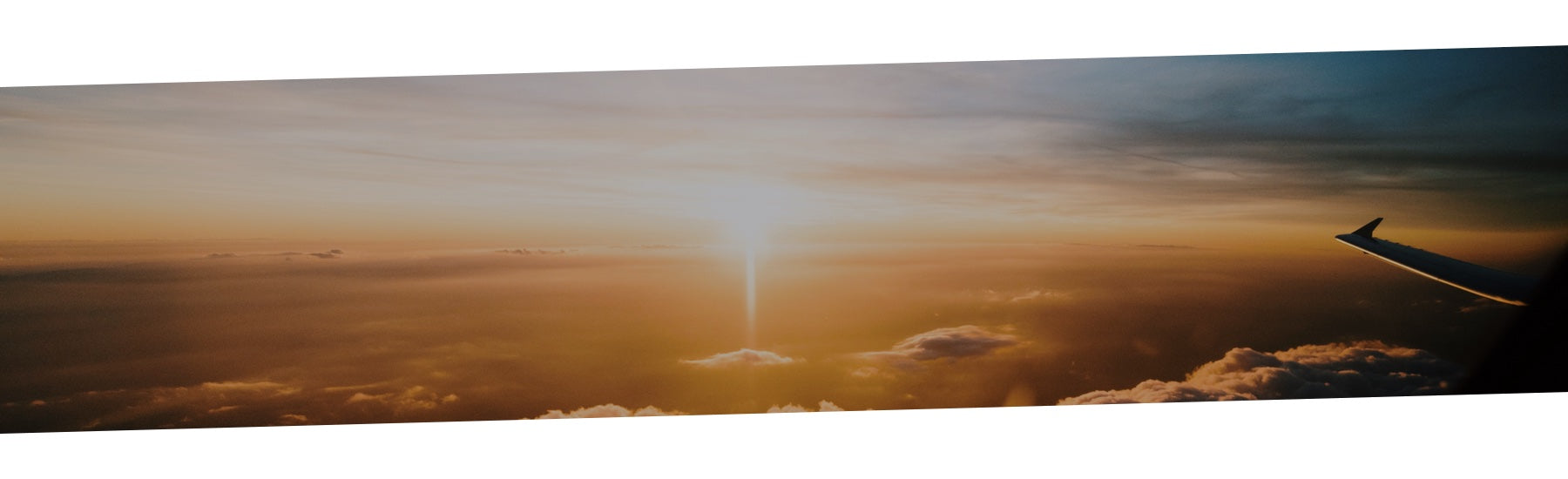 The horizon of the sky with an aeroplane wing in sight.