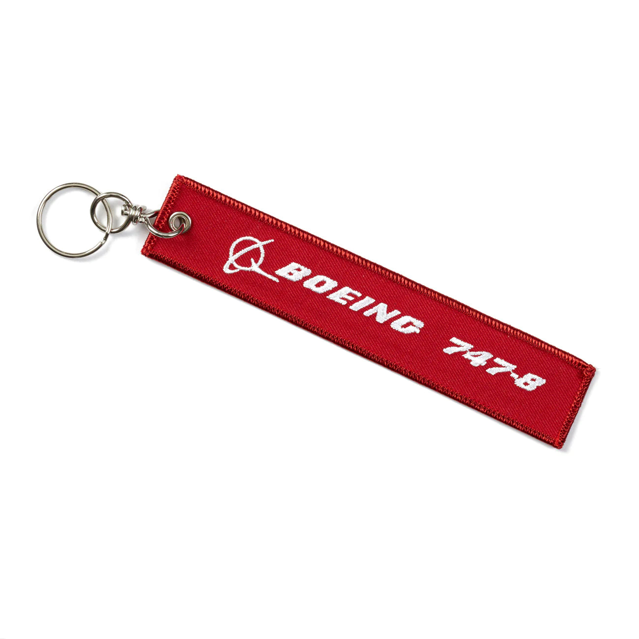 A red remove before flight keychain. It has the words "boeing 747-8" written on it.