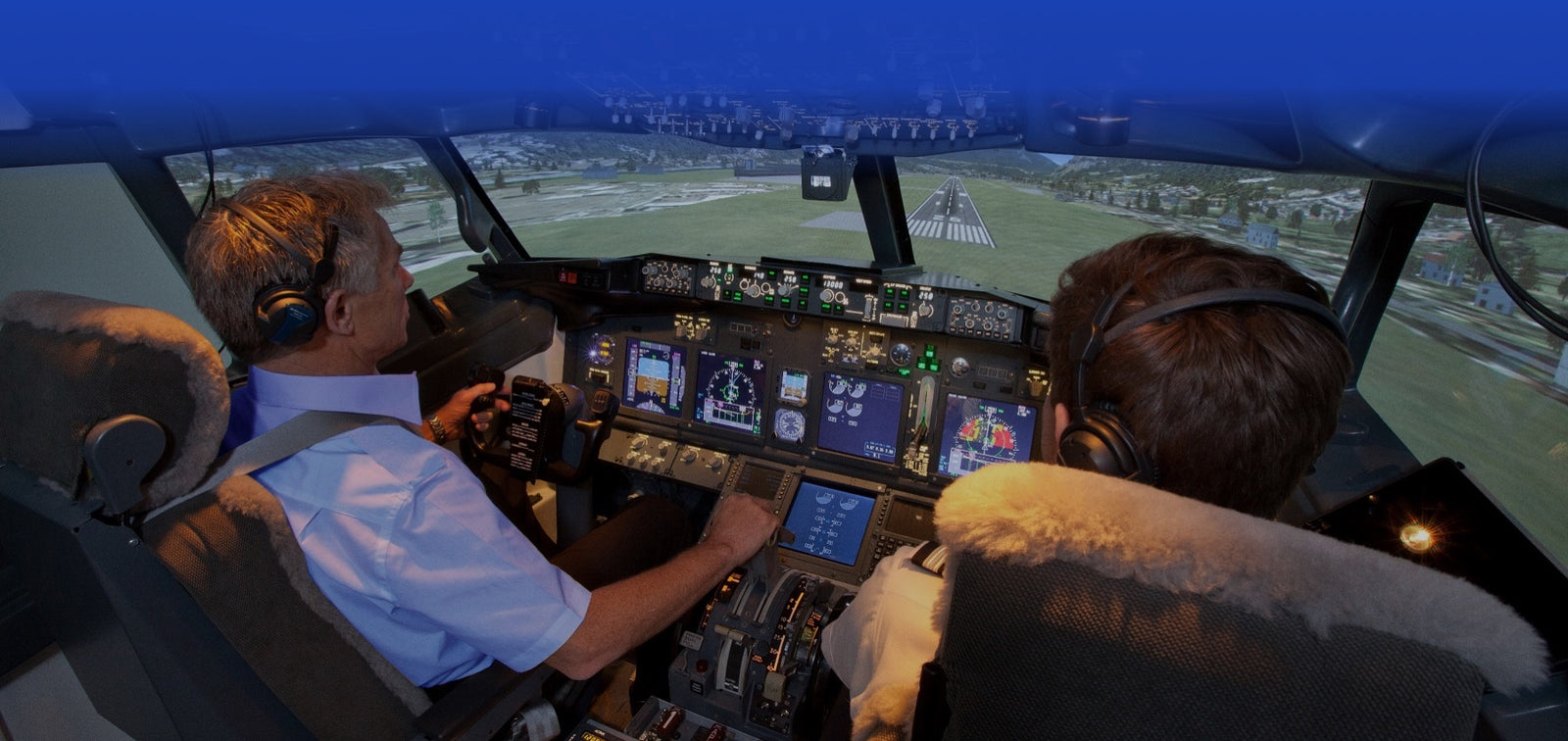 Two pilots sitting in the cockpit of a Boeing 737 simulator.