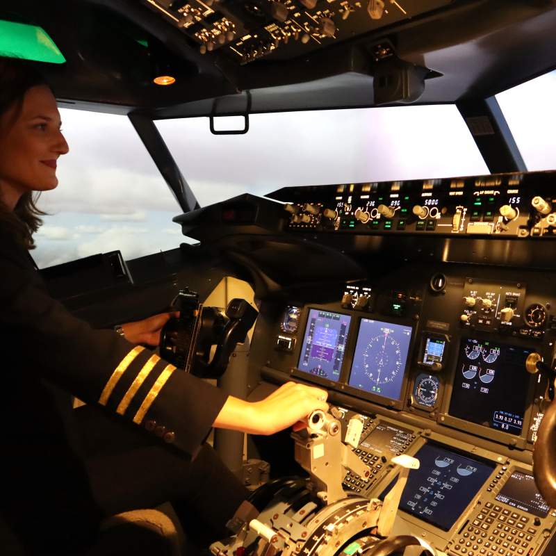 A woman controls the thruster of a Boeing 737 flight simulator at Flight Experience Perth.